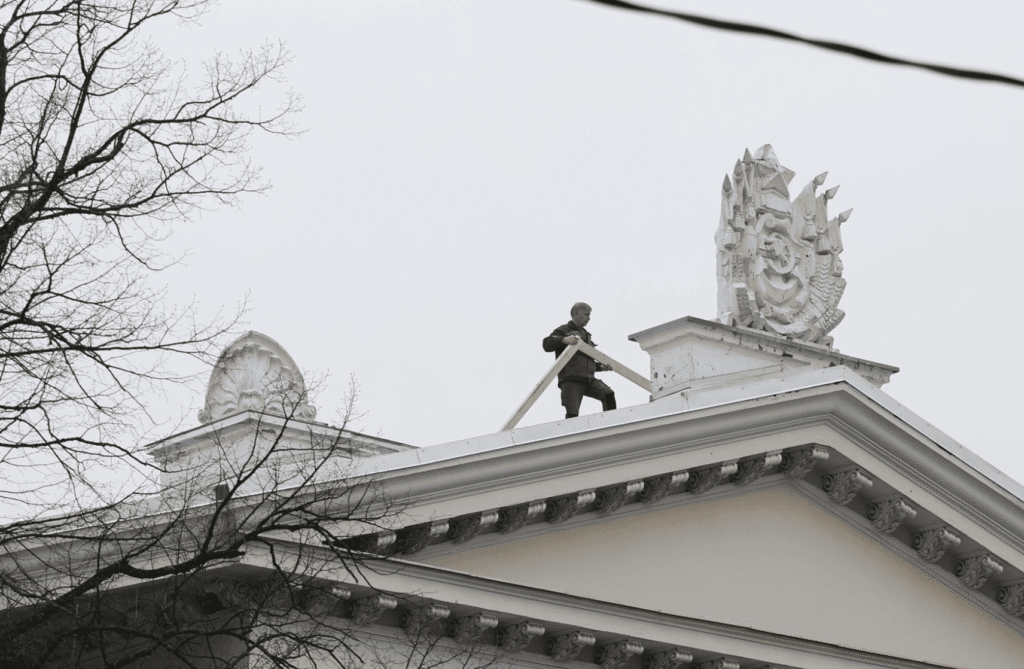 From the facade of the house of Russian culture in Tallinn, the Soviet coat of arms is dismantled